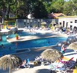 vue d'ensemble de la piscine, des transats et du restaurant du camping Les Rochelets